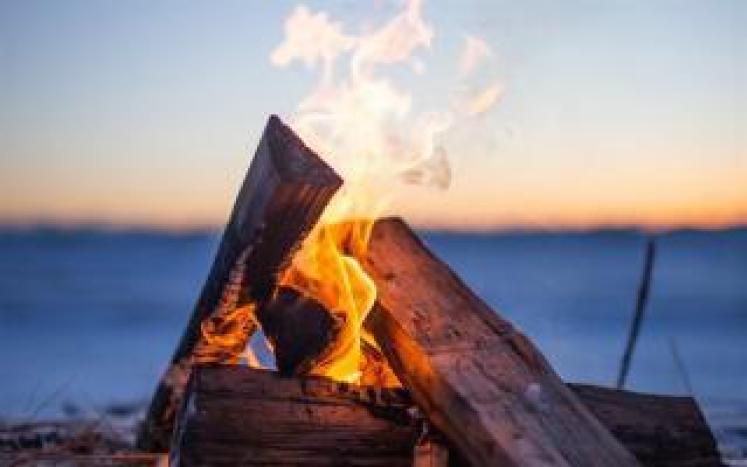 photograph of a small campfire on the beach